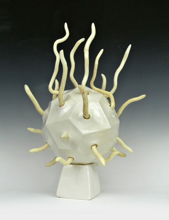 Ceramic sculpture of a 24-sided polyhedron with wooden fingers.