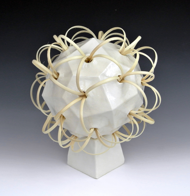 Ceramic sculpture of a 24-sided polyhedron with reed strips.