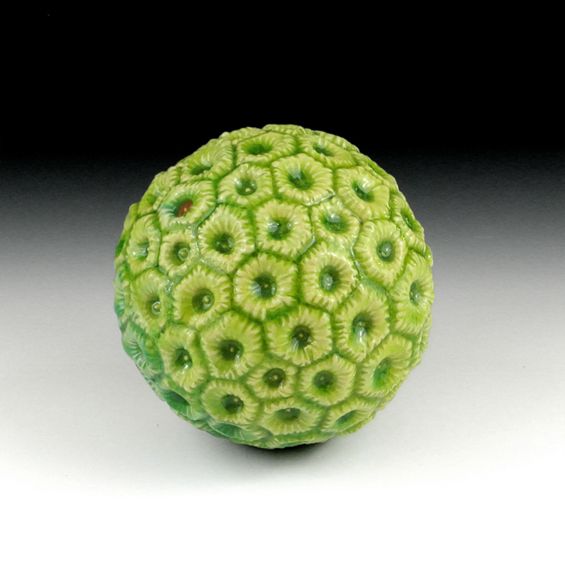 Abstract ceramic sculpture of a spherical form with coral-like features.