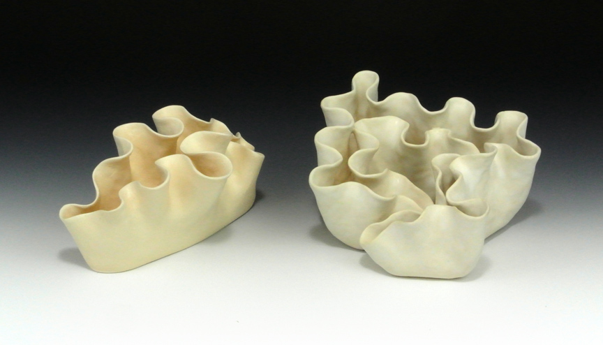 Two ceramic sculptures of abstract forms based on the mantel of lettuce sea slugs.